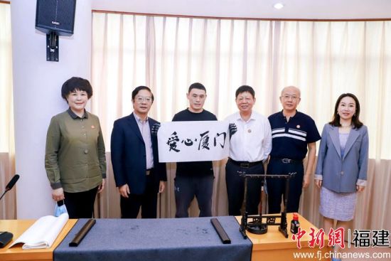 殘障人士代表現場書寫毛筆字“愛心廈門”。