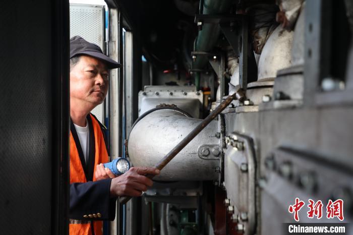 圖為出發前，何志剛檢查內燃機車內部情況?！O嘉奎 攝