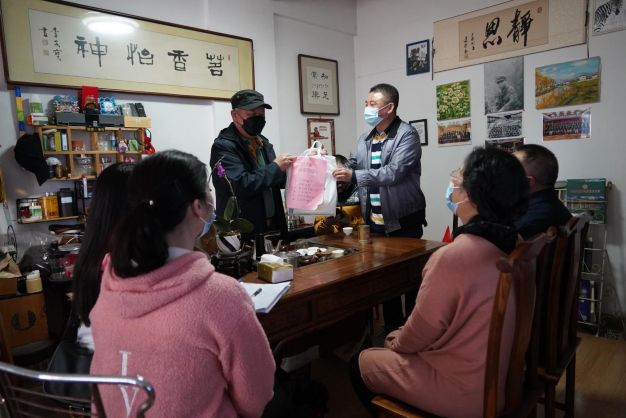 圖為志愿者們給澳門同胞李先生送上防疫用品。1.png