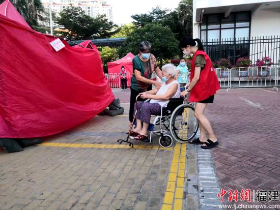 志愿者幫助行動不便的老人。陳向輝 攝