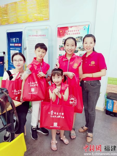 圖為陳霞（右一）帶著大女兒（右二）和小女兒（右三）一起去社區慰問困難群眾。受訪者 供圖