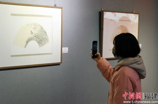 一名女青年用手機拍攝參展作品。記者 劉可耕 攝