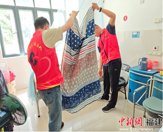 圖為退役軍人高偉彬等在房間內幫忙整理被褥。謝丹供圖。